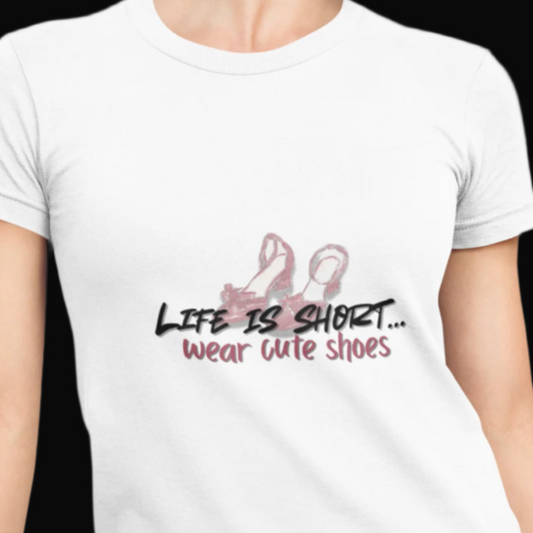 White t-shirt with 'Life is short, wear cute shoes' text and flamingo graphic worn by a person.